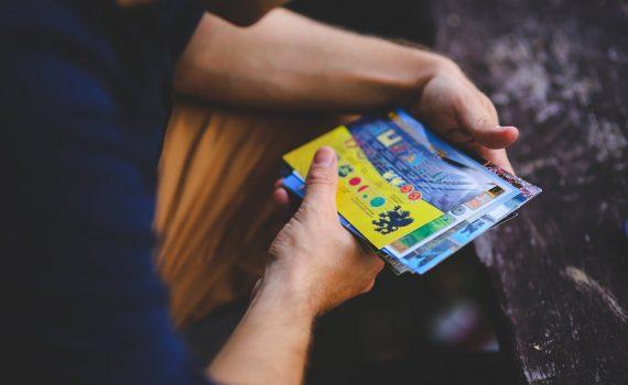 man looking at postcards