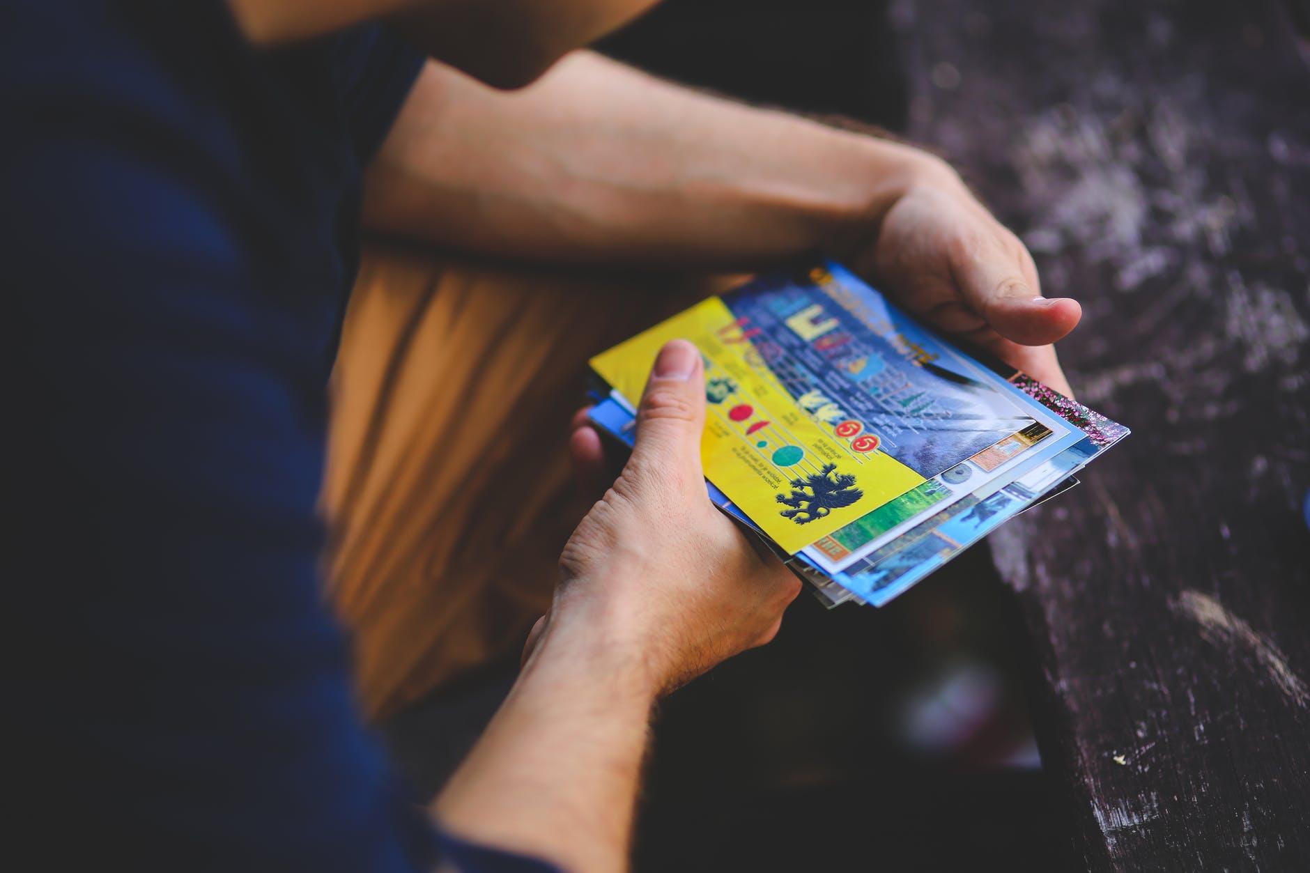 man looking at postcards