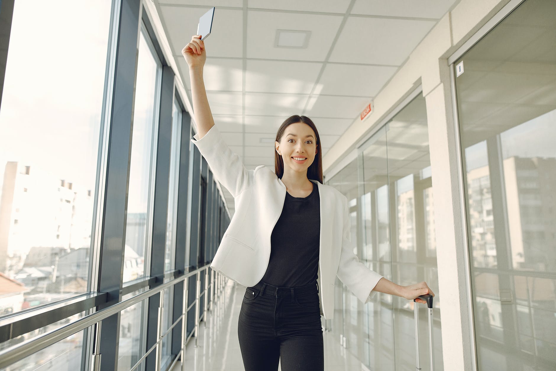 smiling woman showing passport in modern corridor