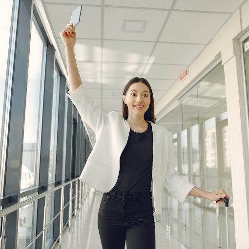 smiling woman showing passport in modern corridor