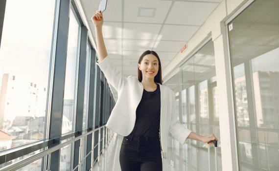 smiling woman showing passport in modern corridor