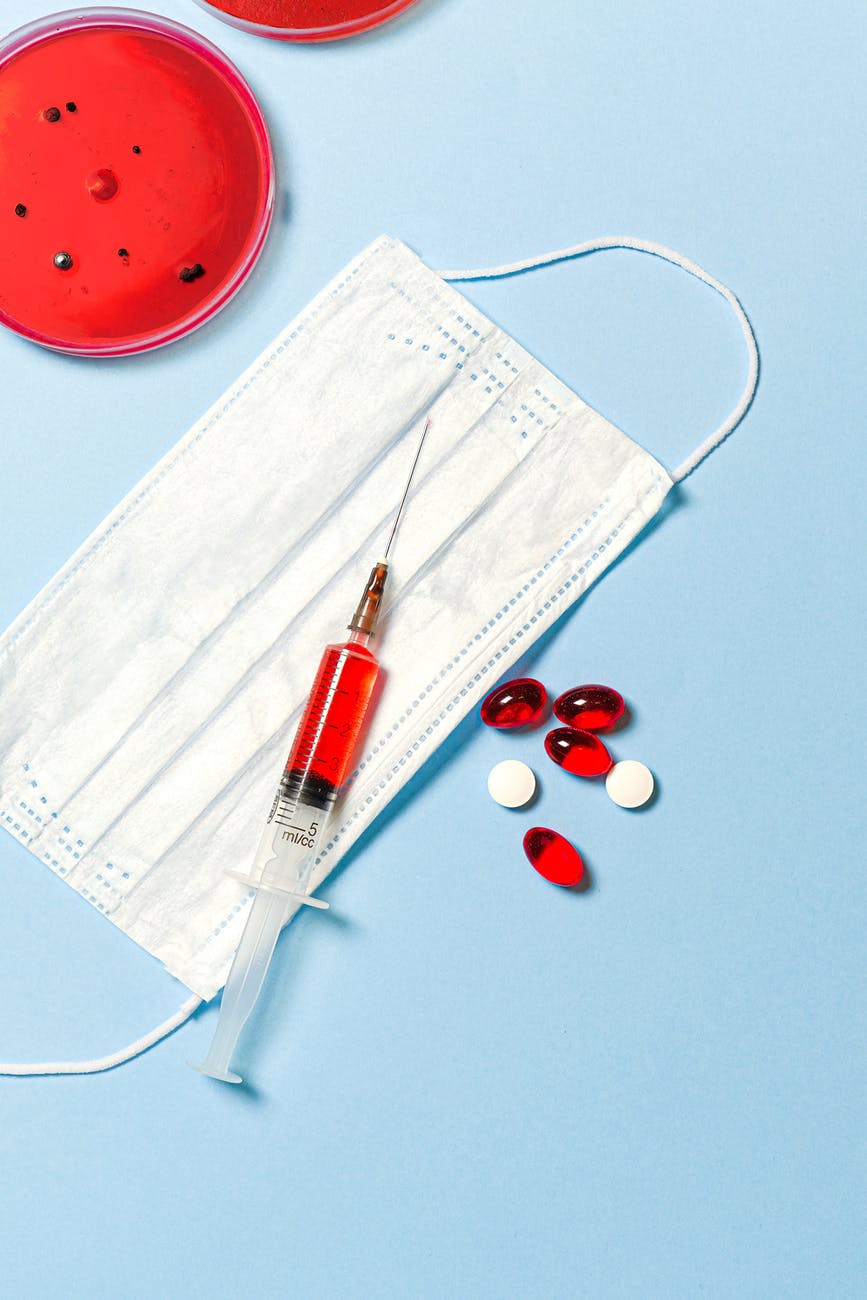 syringe and pills on blue background