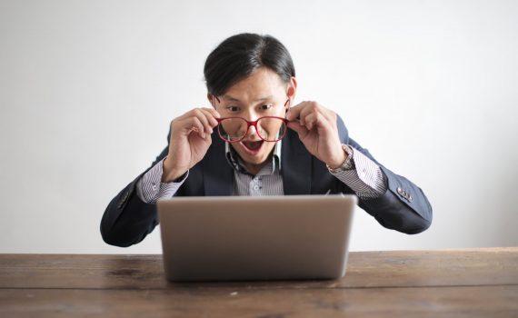 amazed formal male looking at laptop screen