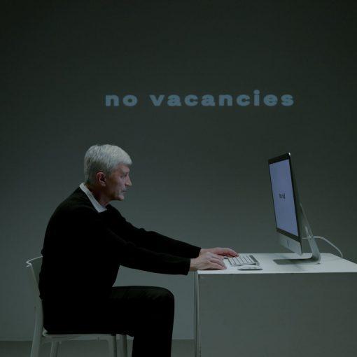 senior adult man sitting in front of pc and writing on keyboard