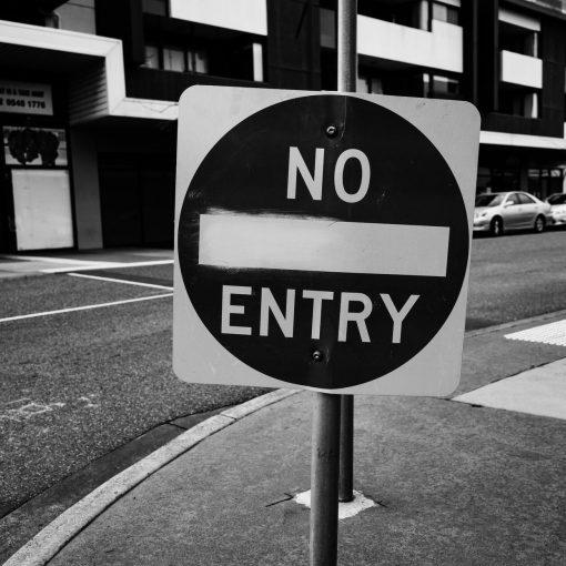 grayscale photo of black and white road sign