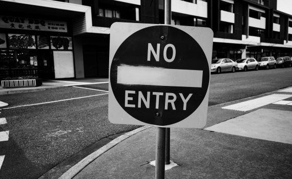 grayscale photo of black and white road sign