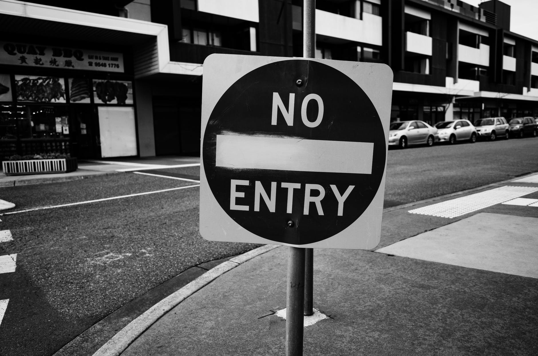 grayscale photo of black and white road sign