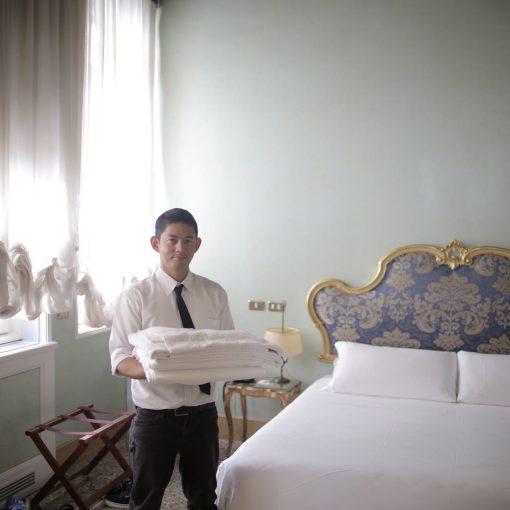 male servant preparing hotel room for guests