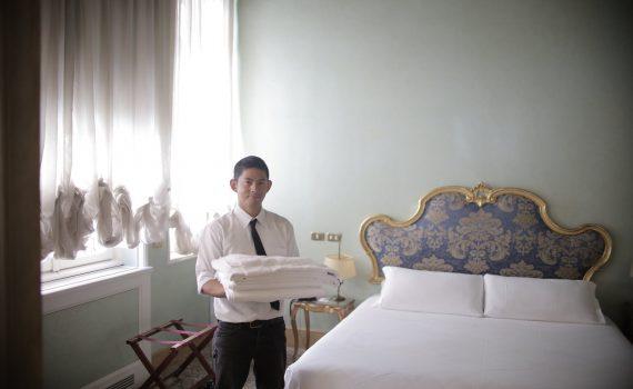 male servant preparing hotel room for guests