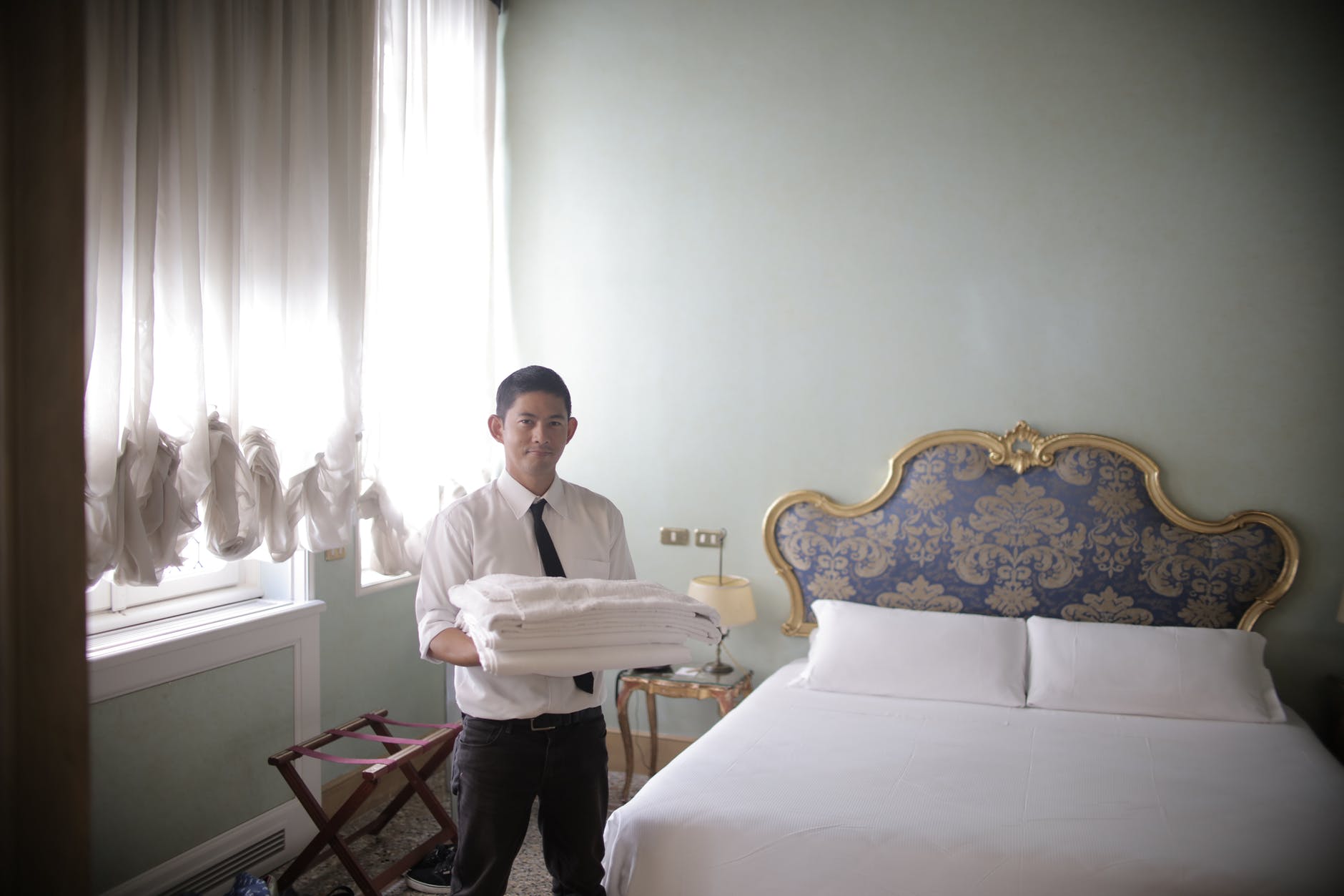 male servant preparing hotel room for guests