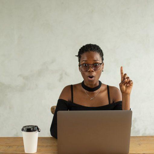 excited black woman using laptop