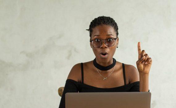 excited black woman using laptop