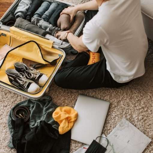 a man packing clothes in his luggage