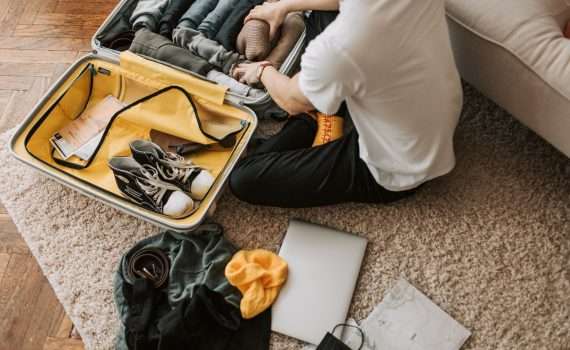 a man packing clothes in his luggage