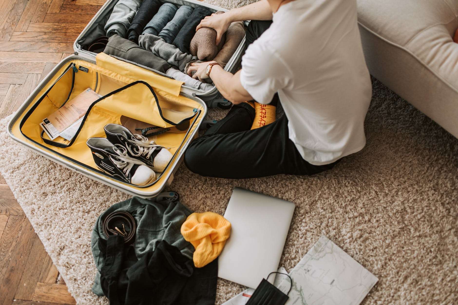 a man packing clothes in his luggage