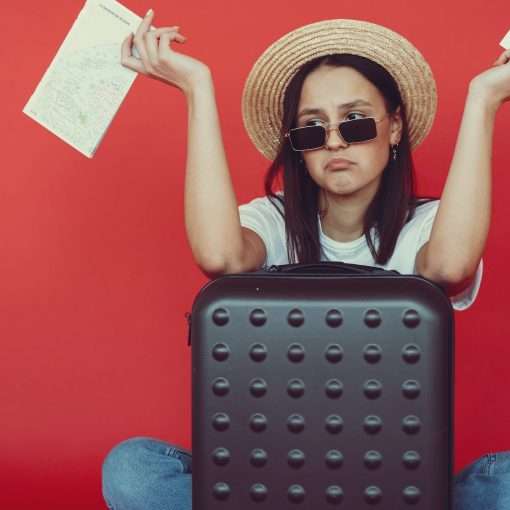 anxious young lady with tickets and passport on red background