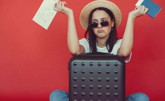 anxious young lady with tickets and passport on red background